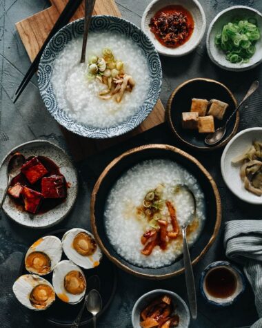 Plain congee topped with pickles, sesame oil and green onion